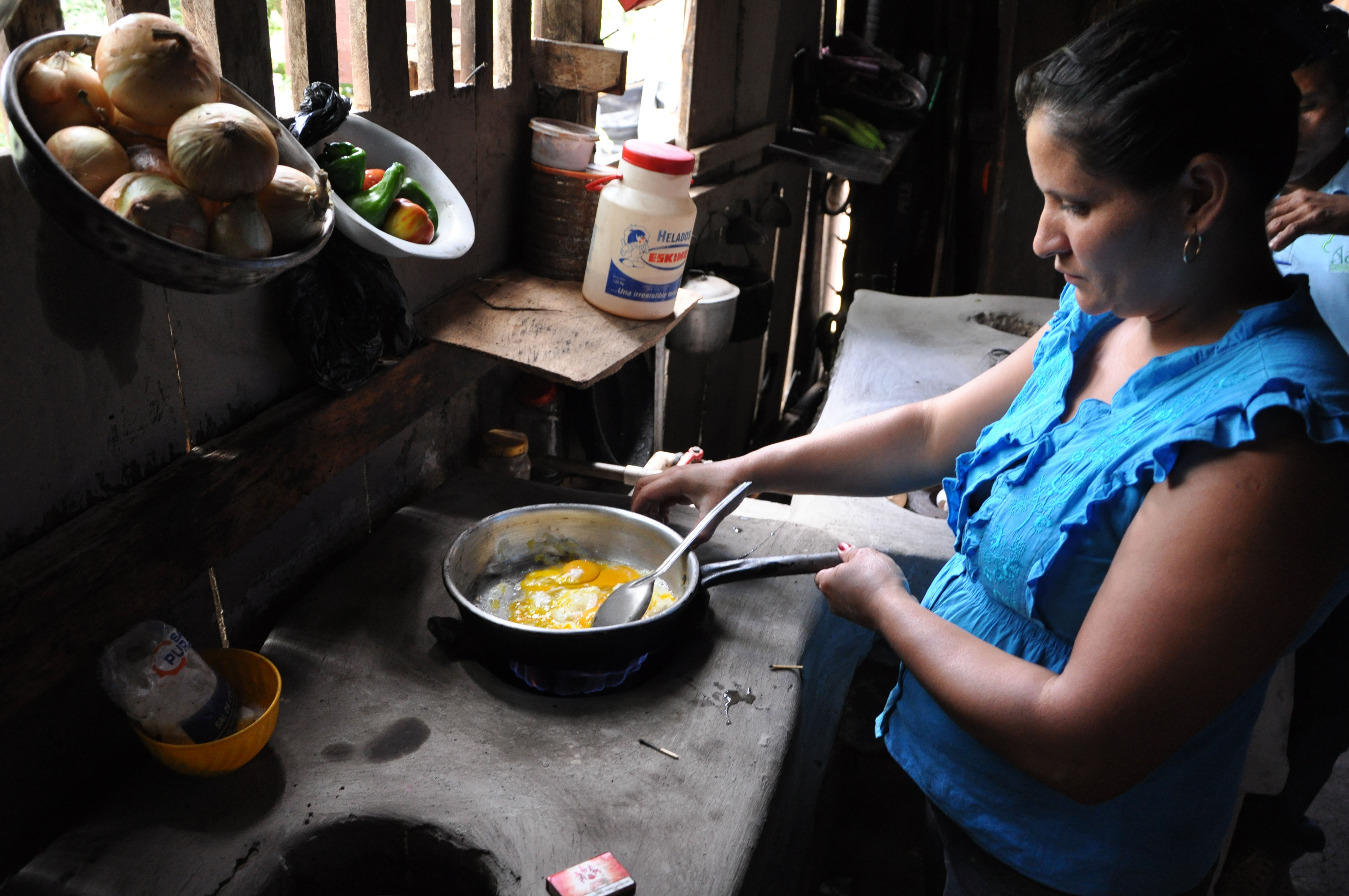 Woman cooking using biogas made from wastewater from coffee processing