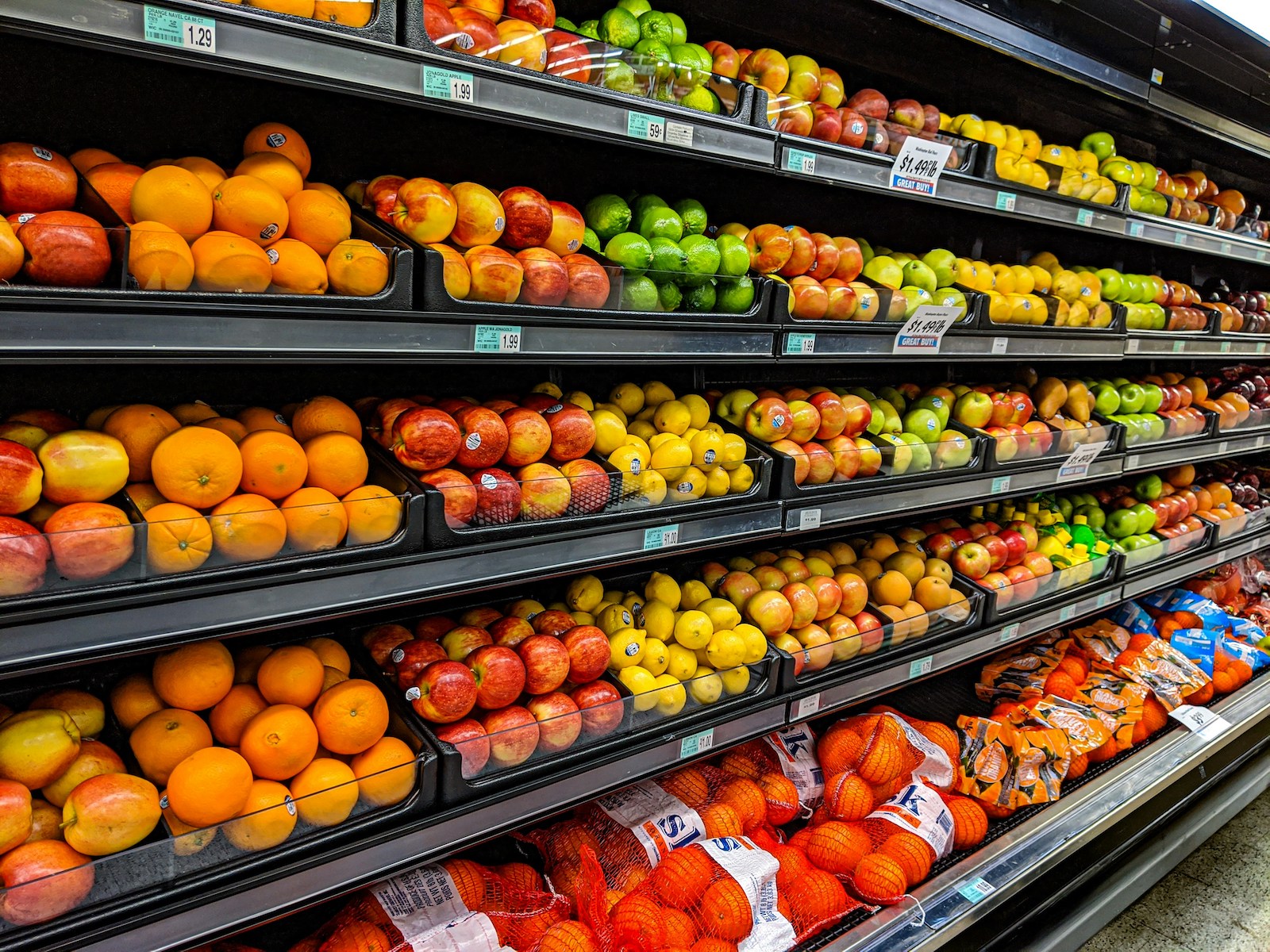 A vibrant fruit display at a grocery store, showcasing colorful fruit such as apples and oranges.